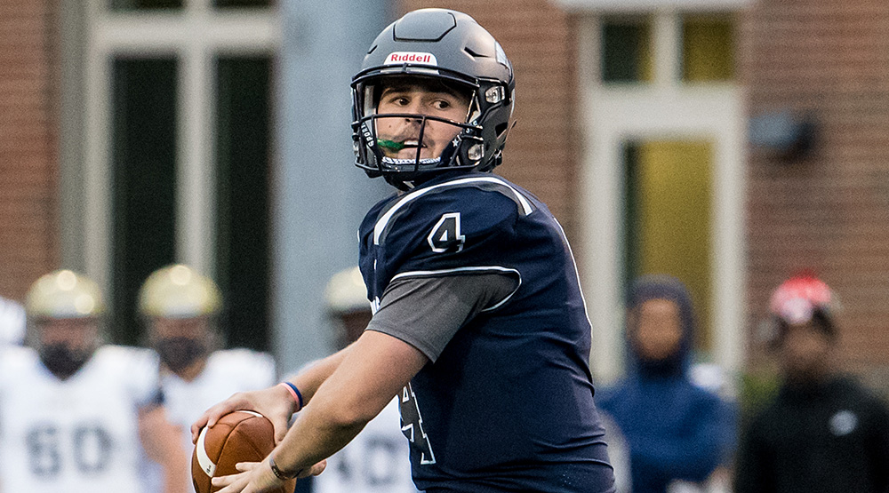 Case Western Reserve freshman quarterback Drew Saxton cocks to throw with Thiel College on the sidelines in the background. (Case athletics photo by Naji Saker)