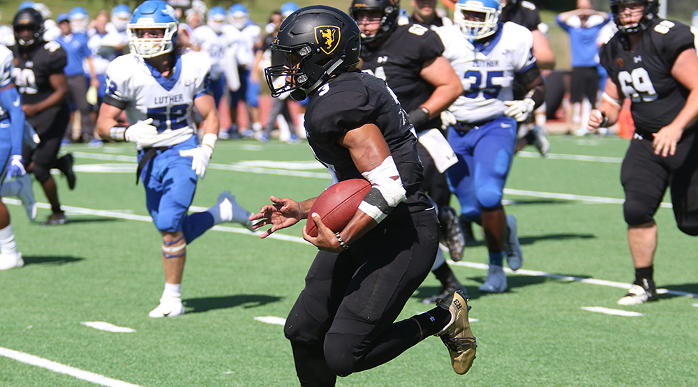 Ricardo Johnson III runs away from Luther defenders. (Photo by Kevin Healy, d3photography.com)
